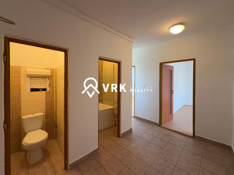 A hallway in a 2-room apartment with tiles and wooden decor flooring in the room.
