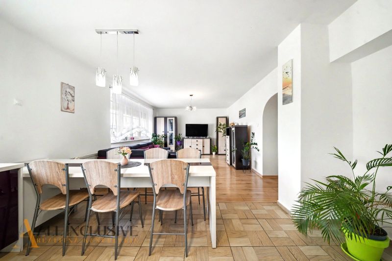 A dining room with wooden floor decor and plants in a family house.