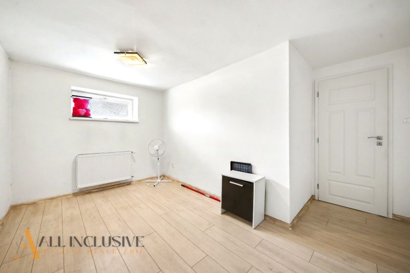 White room with wood-patterned flooring in a family house.
