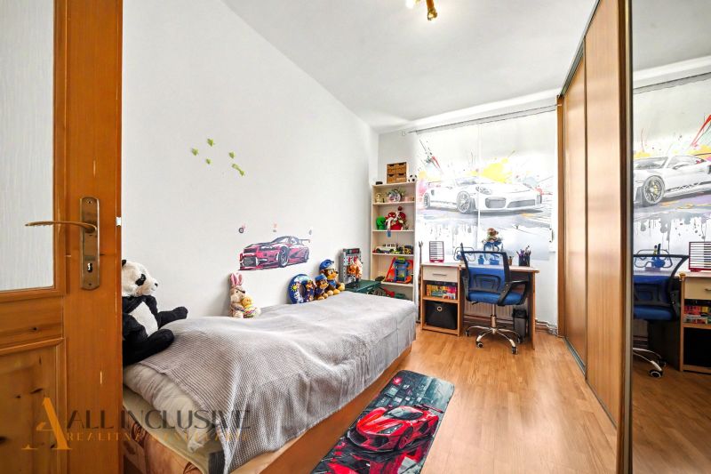 Children's room in a family house with toys, a bed, and a wooden decor floor.