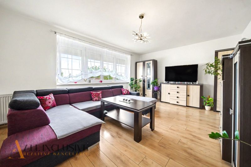 Living room in a family house with a corner sofa and a wooden decor floor.