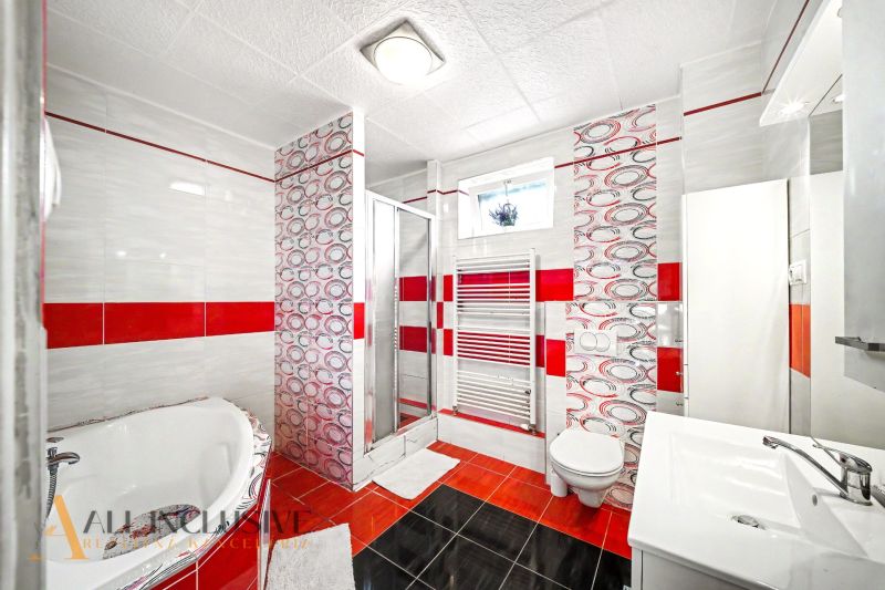 A bathroom in a family house with a bathtub, toilet, and shower.