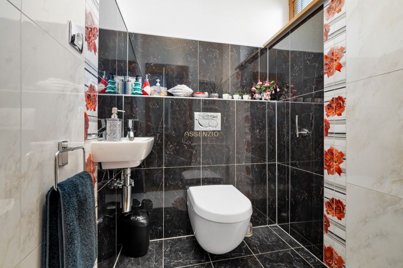 A bathroom in a family house with dark tiles and colorful floral patterns.