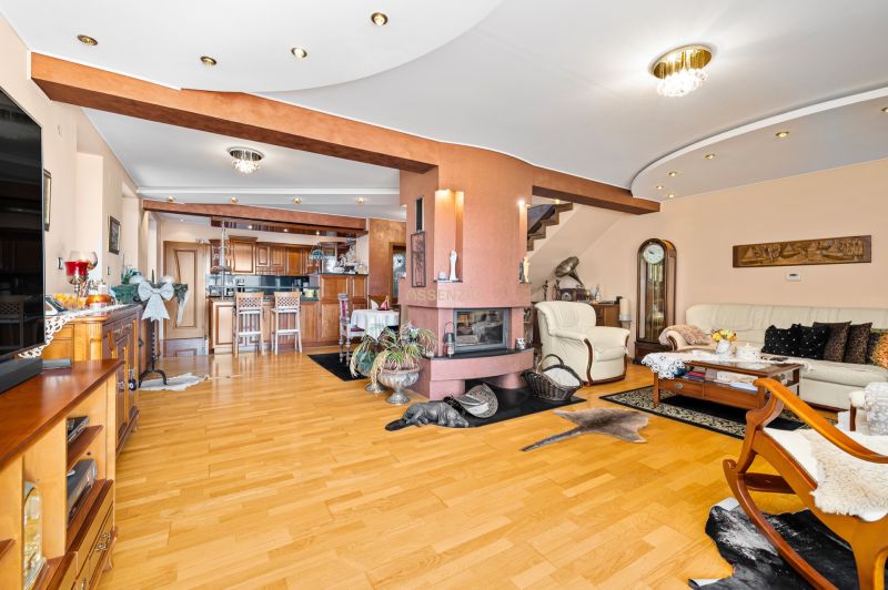 Living room in a family house with a fireplace and a wooden decor floor.