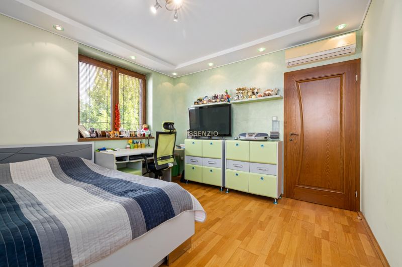 Children's room with a bed, desk, and floor with wooden decor in a family house.