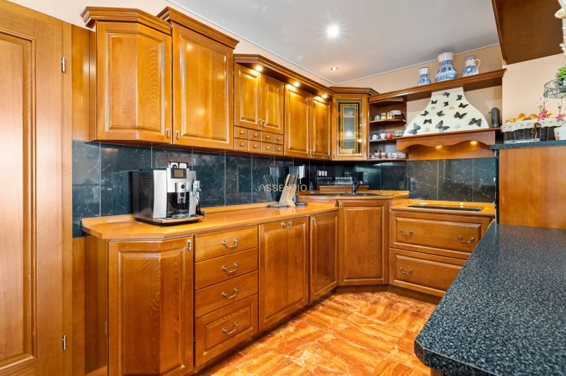 A kitchen in a family house with wooden cabinets and a floor with a wooden decor.