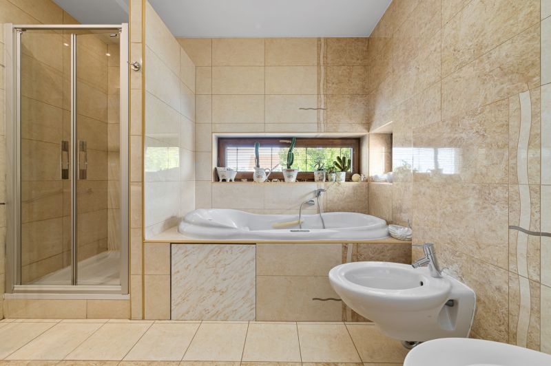 Bathroom in a family house with a bathtub, shower, and bidet.