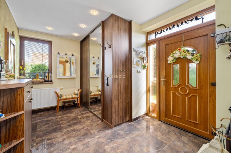Entrance hall in a family house with a large mirror, wooden decor, and decorations.