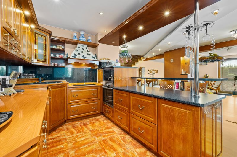 A kitchen in a family house with wooden cabinets and a floor with a wooden decor.
