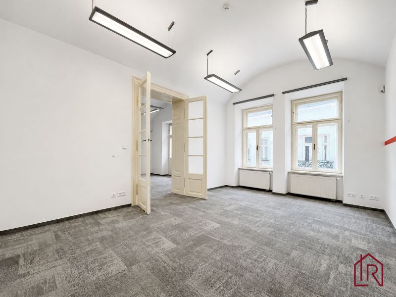 Offices with white walls, large windows, and carpeted floors.