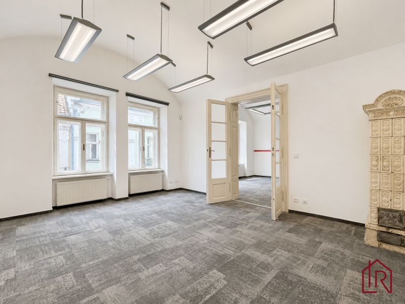 Offices with a tiled stove and pendant lights, floor with wooden decor.