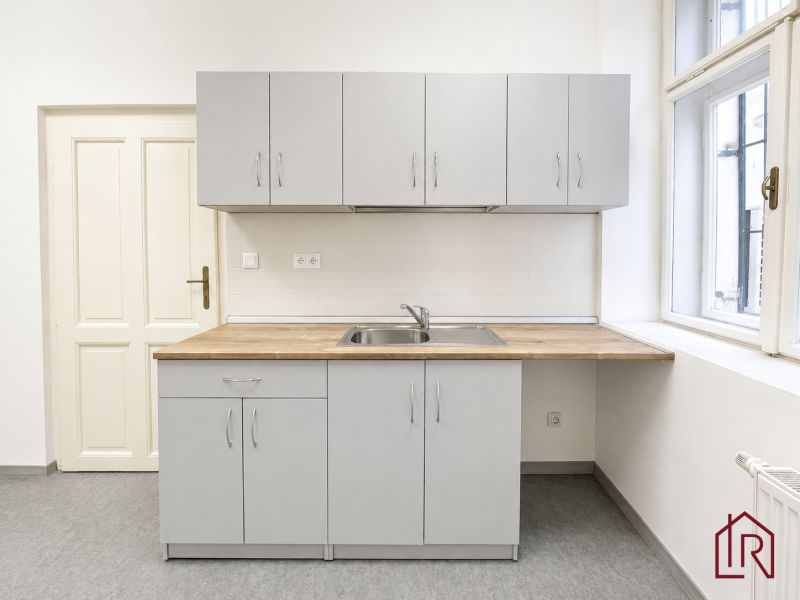 Gray kitchen unit with a wooden countertop in the office.