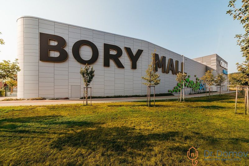 Bory Mall shopping center with a sign, grassy area, and trees in Bratislava-Lamač.