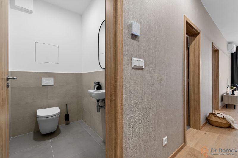 Hallway and toilet in a 2-room apartment with a wooden decor floor.