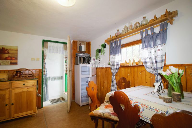 Interior of a cabin with wooden decor, traditional furniture, and a decorated window.