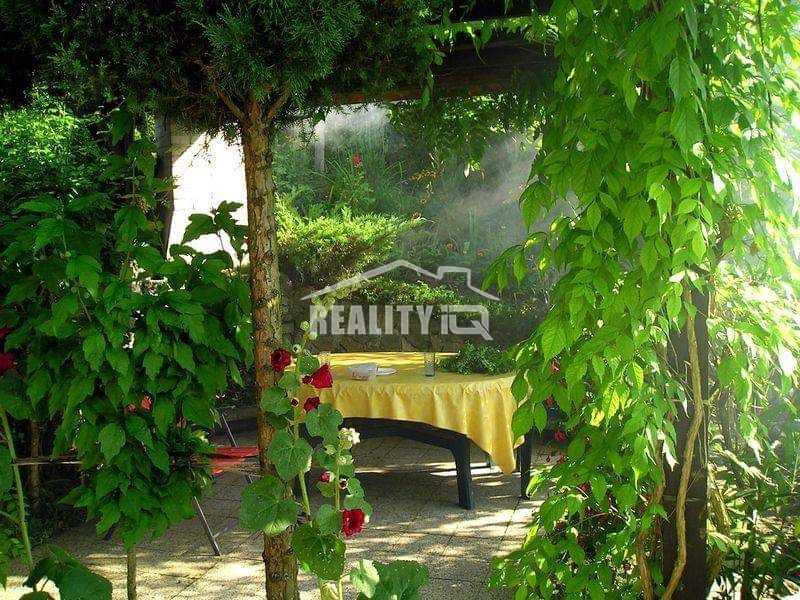 Garden seating by the cottage in Žilina, surrounded by greenery and flowers.