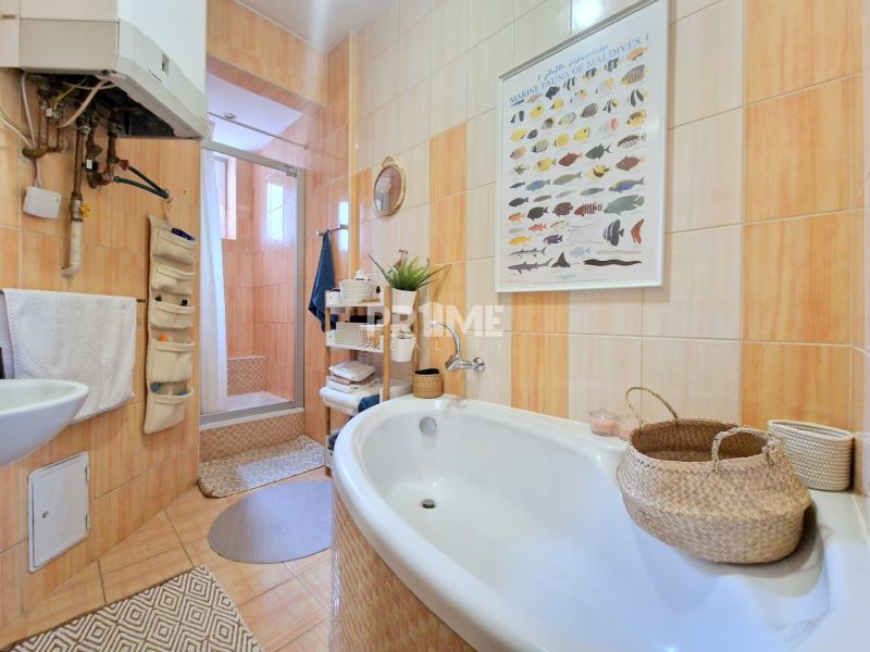 A bathroom in a 3-room apartment with a bathtub, shower, and baskets for accessories.