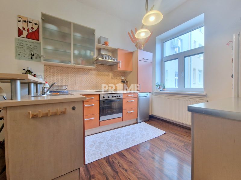 A kitchen with orange cabinets, a wooden decor floor, in a 3-room apartment.