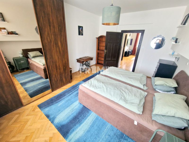 A bedroom in a 3-room apartment with a bed, a mirrored wardrobe, and a blue carpet.