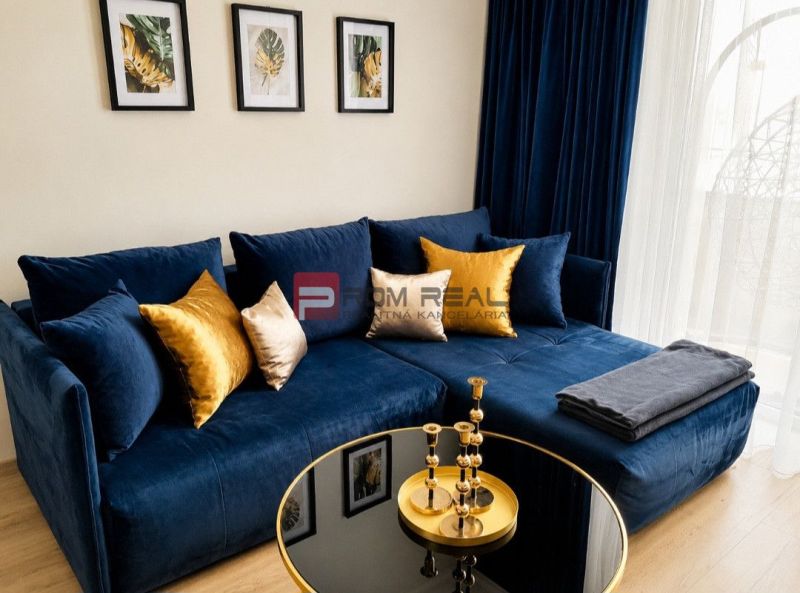 Blue couch with pillows, coffee table, decorations, wooden decor flooring.