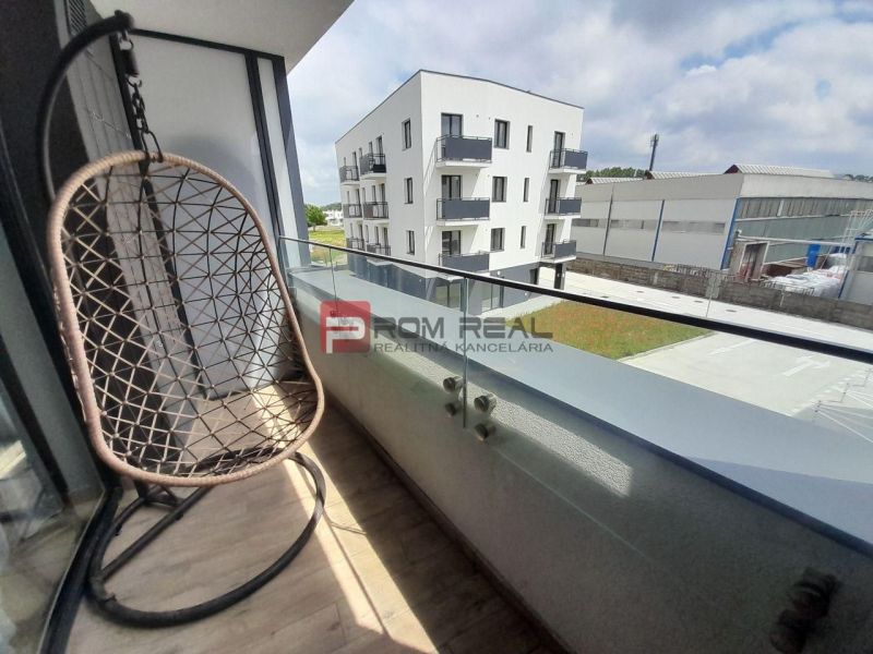 The balcony of a 2-room apartment on Slnečnicová Street in Rovinka with a swing and a view of the surroundings.