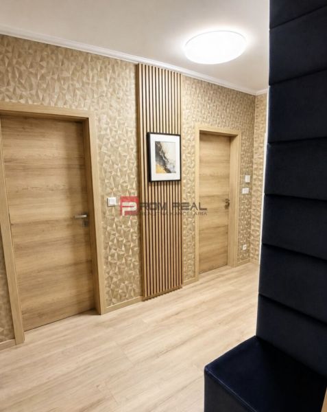 A hallway in a 2-room apartment with a textured wall and a floor with a wood decor.