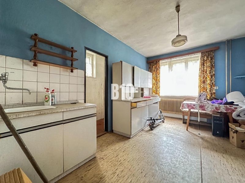 A kitchen in a family house with furniture and flooring featuring a wood design.