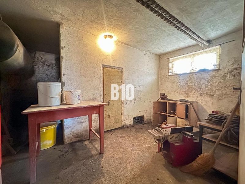 The basement of a family house with furniture and buckets on the table.