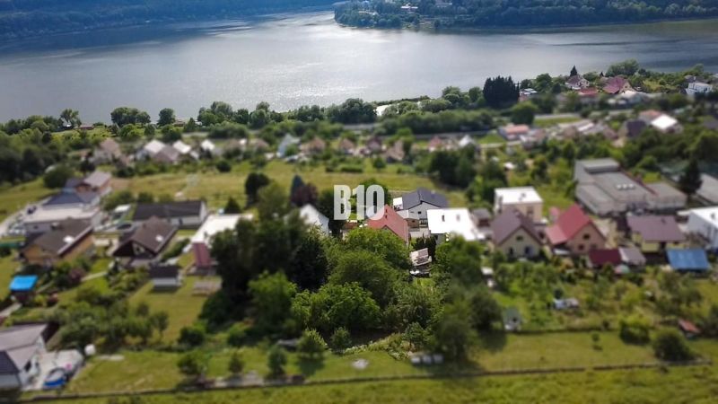 Spacious gardens and family houses in Považská Bystrica with a view of the water surface.