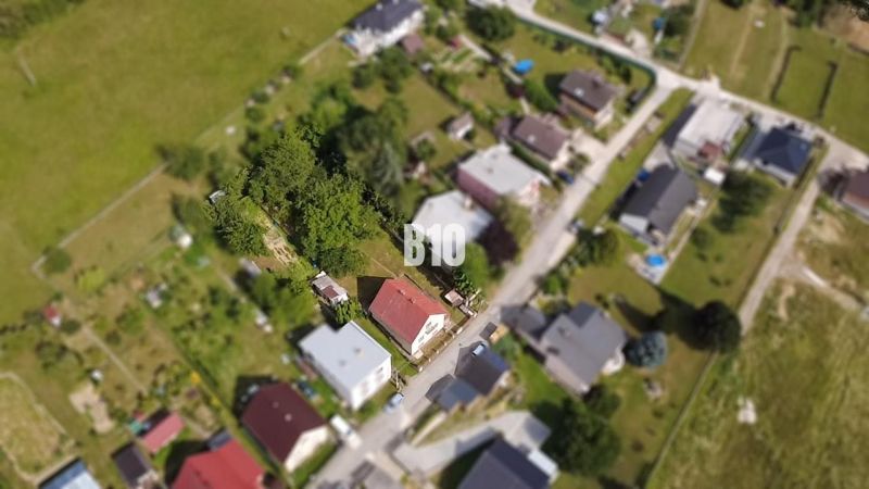 Aerial view of a family house in Považská Bystrica surrounded by greenery and other houses.