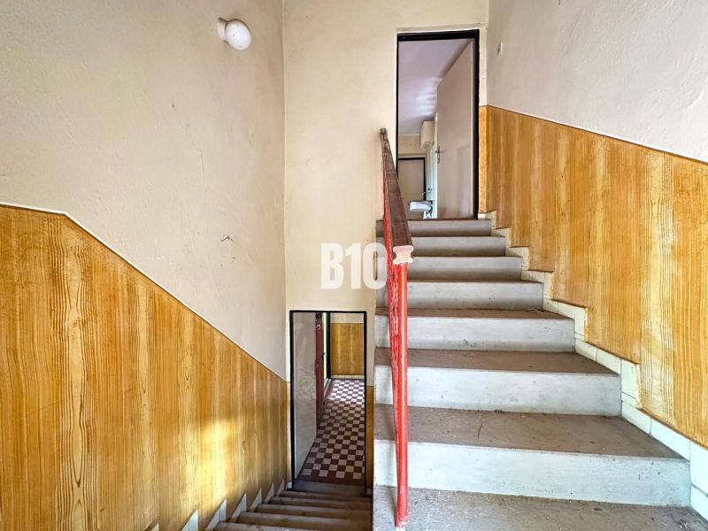 A staircase with a railing and walls with wooden decor in a family house.