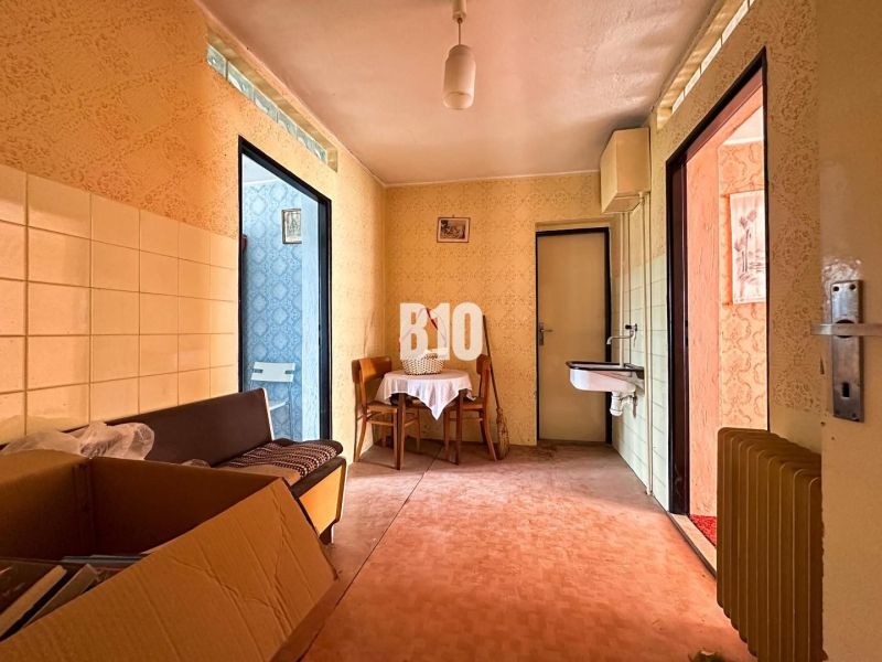 Interior of a family house with a sink, table, and a box on the floor with a wooden decor.