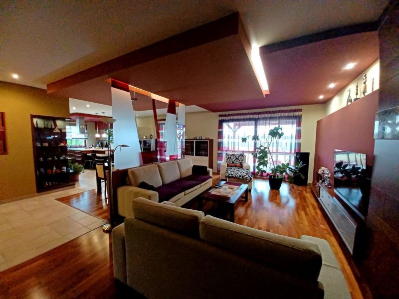 Living room in a family house with a wooden decor floor and comfortable seating.