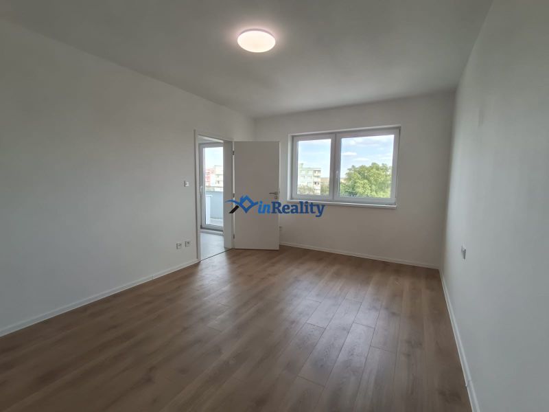 A bright room in a 2-room apartment with a wooden decor floor.