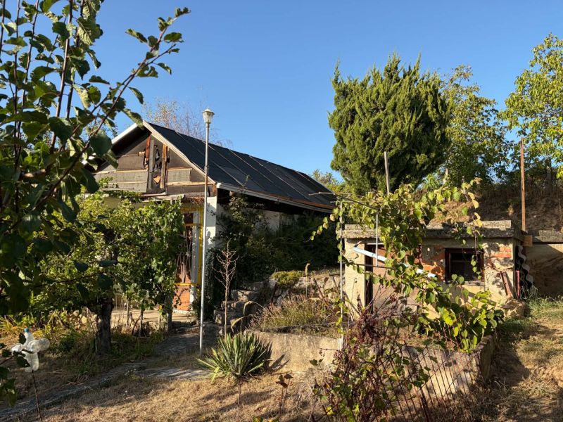 A cottage in Banka surrounded by lush greenery under a blue sky.