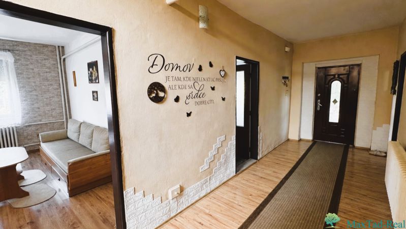A hallway in a family house with wall decorations and a wooden decor floor.