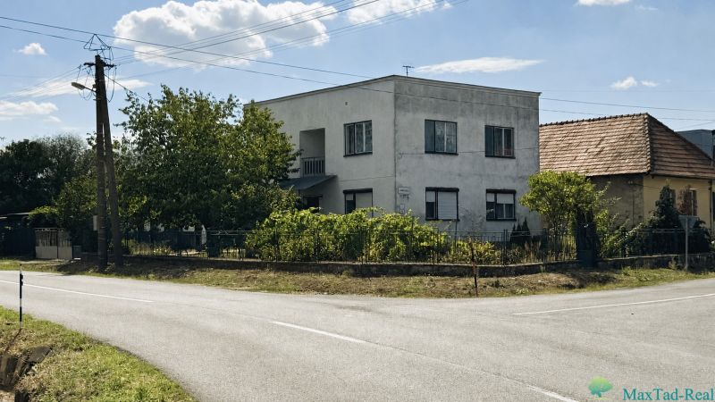 A family house on Jarná Street in the town of Novosad, surrounded by lush vegetation.