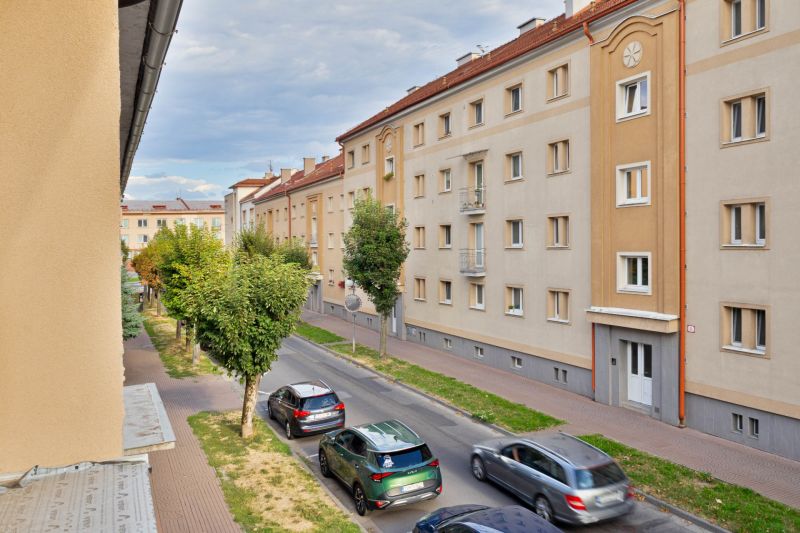 Študentská Street in Zvolen with apartment buildings and passing cars, suitable for a studio apartment.
