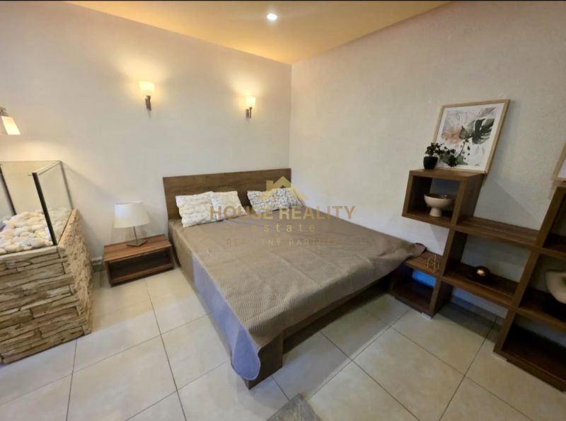 Bedroom in a studio apartment with stylish decor, wooden elements, spacious bed.