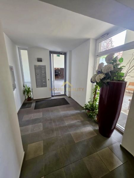 Entrance hall with flowers and mailboxes, bright space.