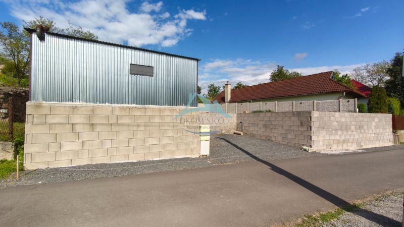 A sheet metal building and a block wall by the road at the Recreational Grounds in Záhorce, Selešťany.