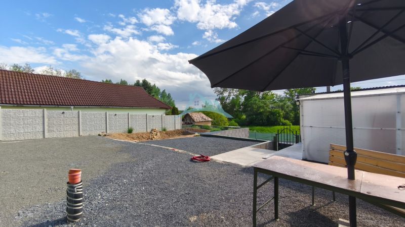 A courtyard with a stone surface and a large sunshade at the Recreational Grounds in Záhorce, Selešťany.