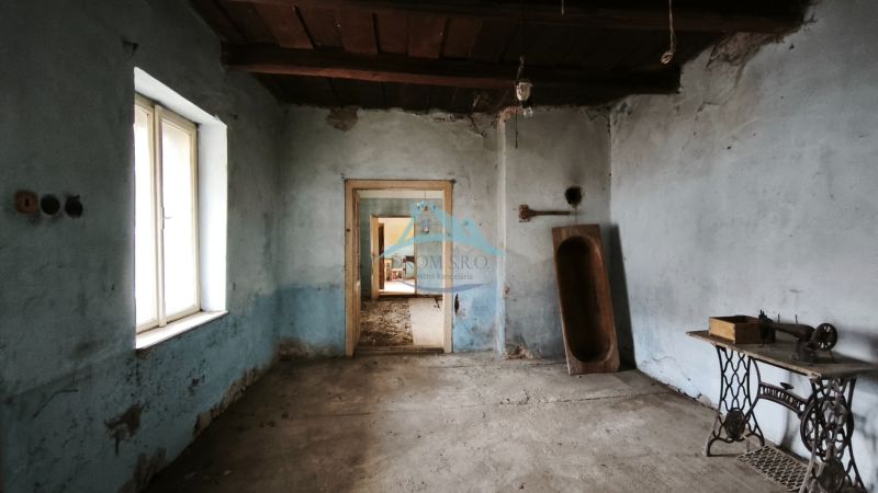 A room in a family house with blue walls, an old sewing machine, and a wooden trough.