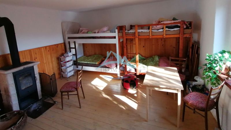 Bunk beds, wood-burning stove, and furniture in the room in a family house.