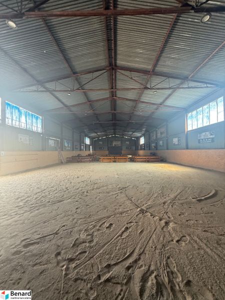 The interior of a building with a large spacious playground and a metal roof.
