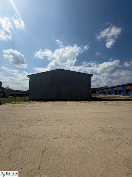 A building in Hniezdne with a large paved area and a blue sky.