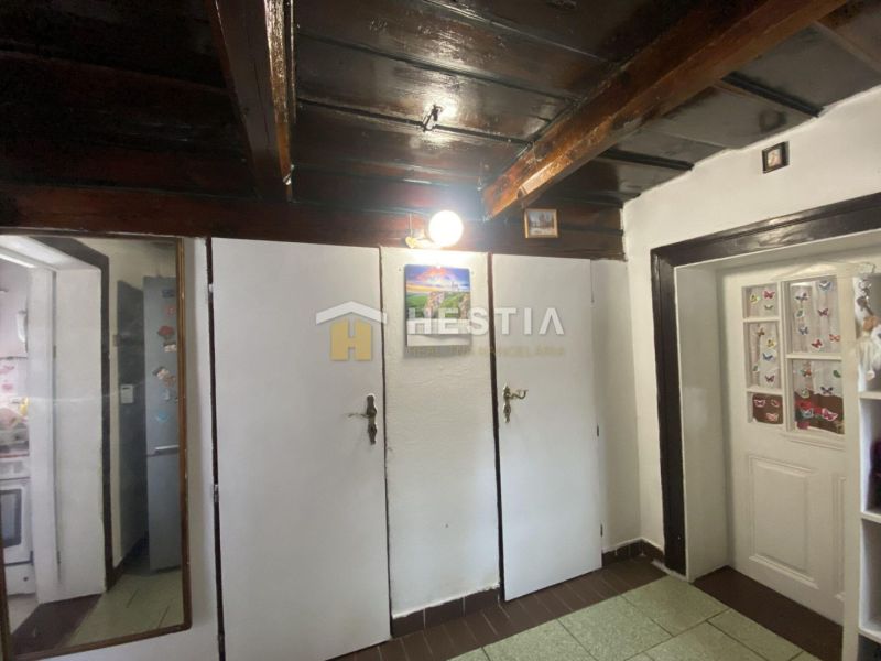The hallway of a family house with wooden ceiling paneling and white doors.