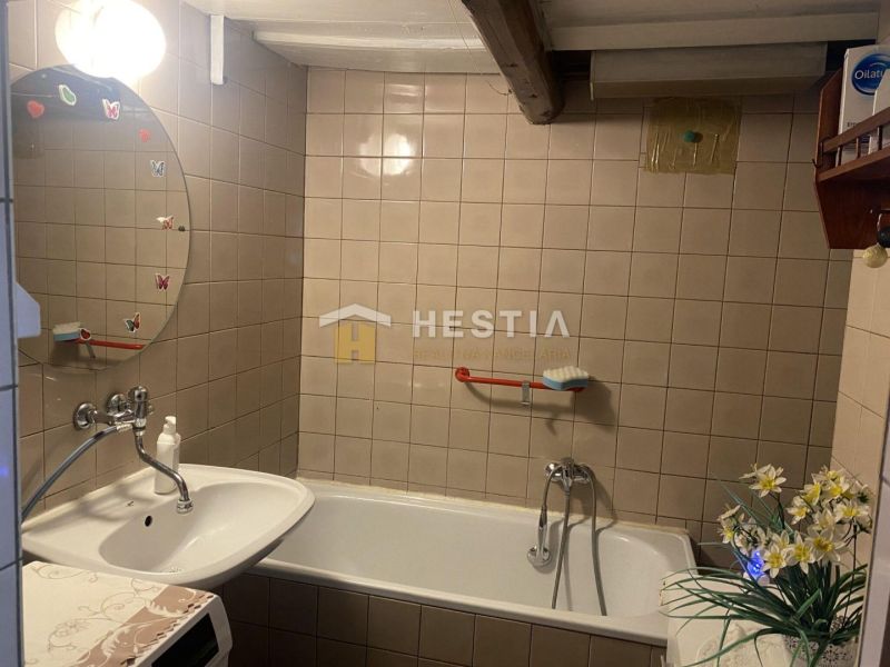 Bathroom with a bathtub, sink, and mirror with decoration in a family house.
