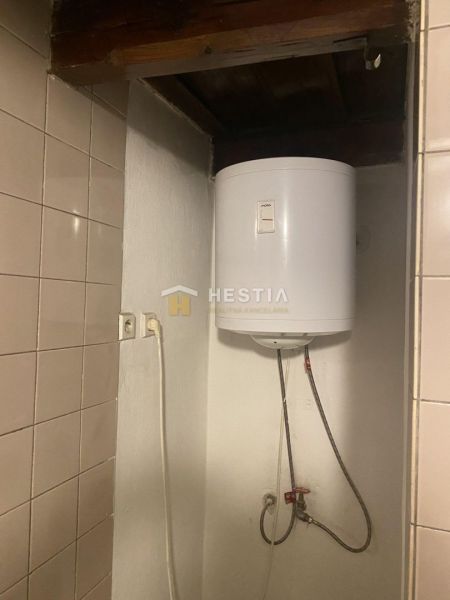 A boiler in a family house with ceramic tiles on the wall.