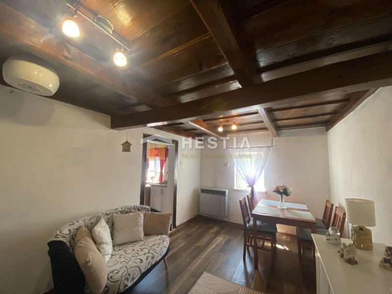 Living room in a family house with a wooden ceiling and a floor with a wooden decor.